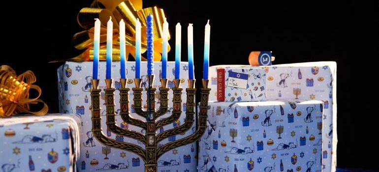 Hanukkah candle holder with wrapped gifts in the background.