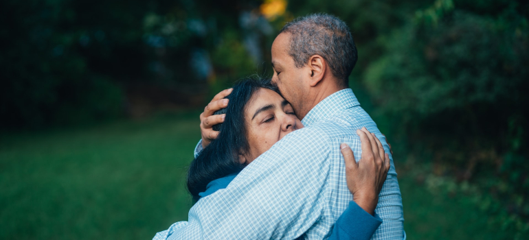 An elderly couple hugging after delirium tremens treatments