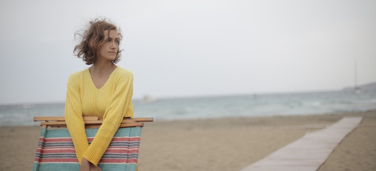 girl on the beach holding a chair during an alcohol addiction treatment in Lantana