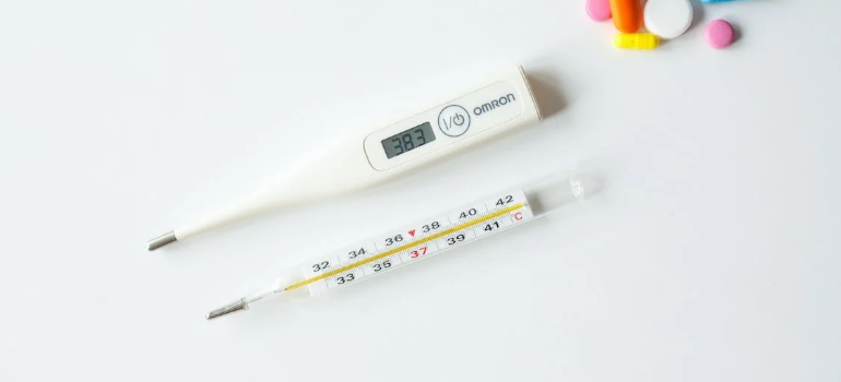 A photo of two thermometers on a white table. 