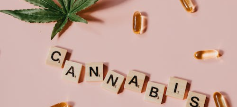 Scrabble Pieces on Pink Surface with Marijuana Leaf