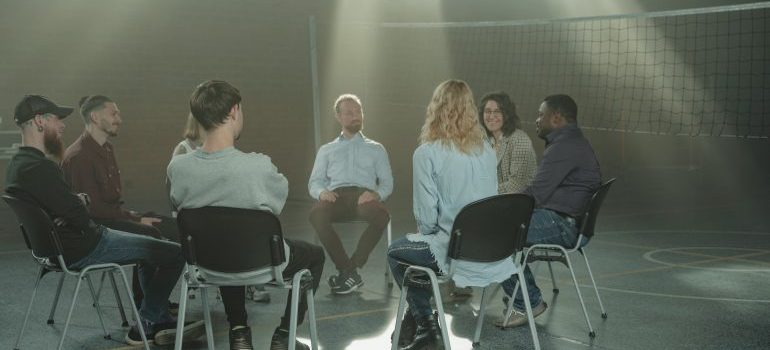 Recovering individuals seated in a circle during an AA meeting.