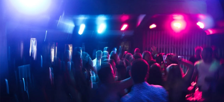 A blurry photo of young people dancing in a nightclub.