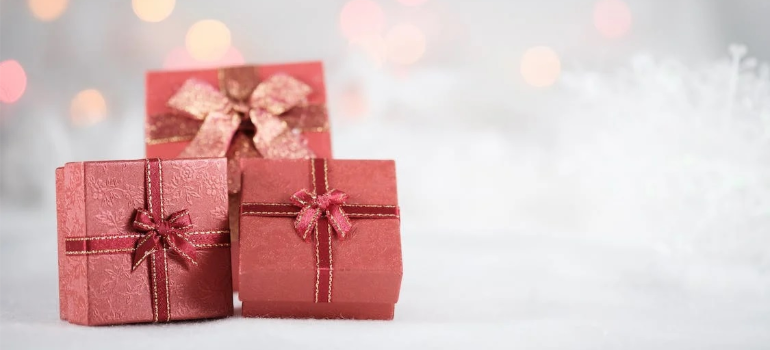 Three red gift boxes on a white surface.
