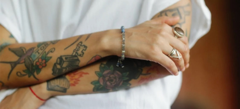 A close-up of a young person’s hands featuring colorful tattoos.