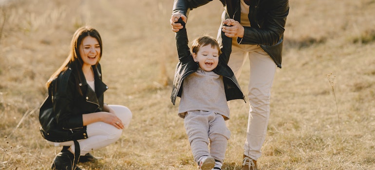 parents laughing with their toddler outdoors