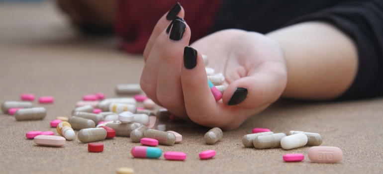 pills in a woman's hand, representing The Alarming Rise of Drug Overdoses in the US