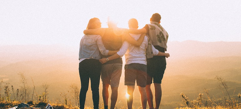 group of people hugging and sunset-watching