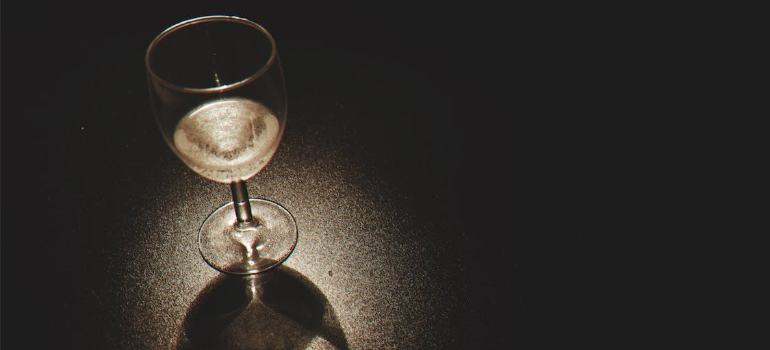 A glass of wine on a black surface.