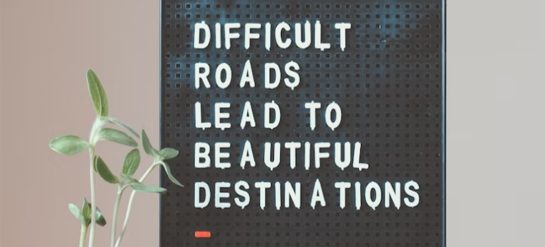 Desk décor that reads “difficult roads lead to beautiful destinations”.