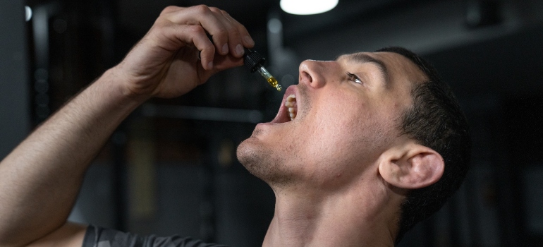 Man using CBD oil to show how can CBD play a role in addiction recovery