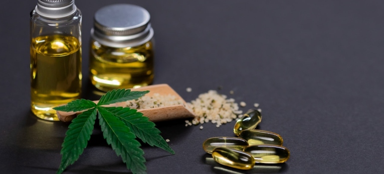 CBD oil next to Cannabis leaf and supplements 