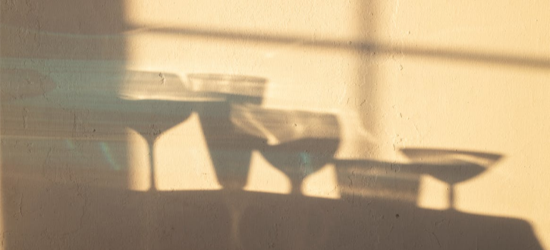 Shadows of glasses of alcohol on a wall, illustrating how there is no amount of acceptable alcohol during pregnancy.