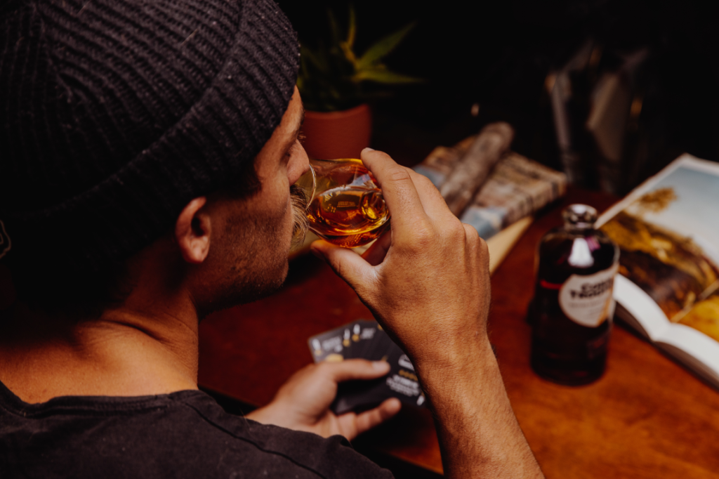 Man with a beanie giving into the effects of alcohol and drinking